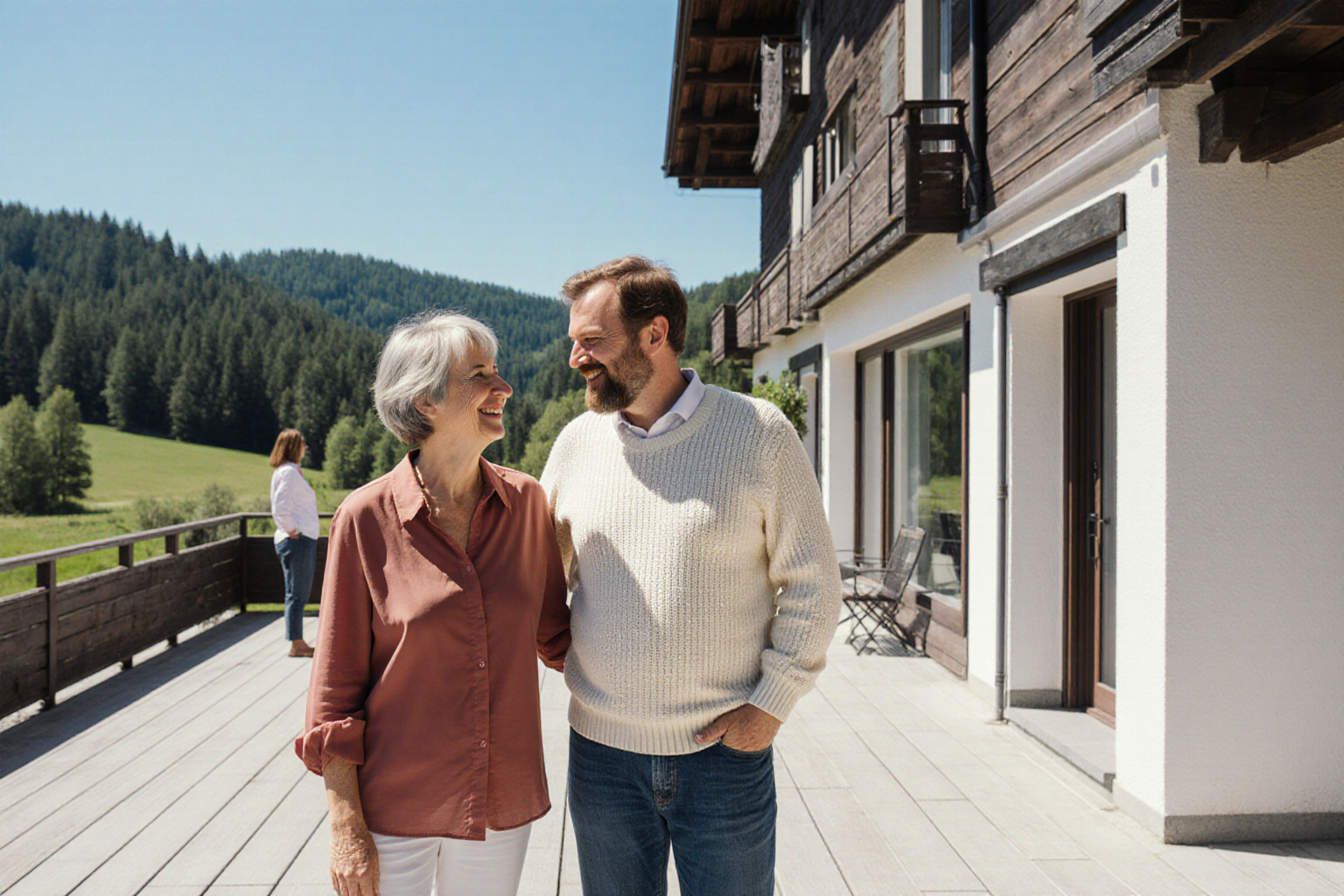 Herzliches Gespräch an einer normalen süddeutschen Freizeitwohnung mit regionaler Holzfassade, Terrasse und grünem Hügelland